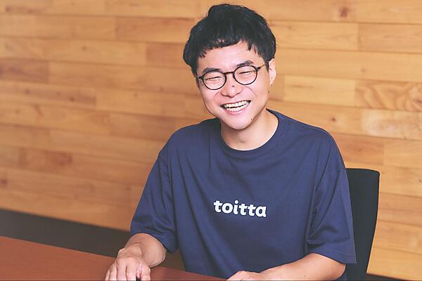 米山弘恭さんの写真。満面の笑みで取材に答えている様子。