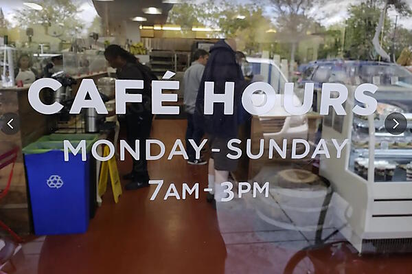 店のフロントガラスに営業時間が書かれている写真