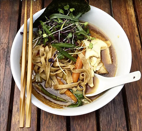 これから食べようとしているヌードルスープが、箸とレンゲとともに清潔なテーブルの上に置かれており、食欲をそそる