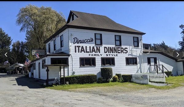店名が大きく書かれた古いイタリアンレストランの写真で、十分に明るいため建物全体がよく見える