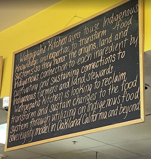 レストランの黒板に、その土地固有の食材に関するビジネスの企業理念が書かれている